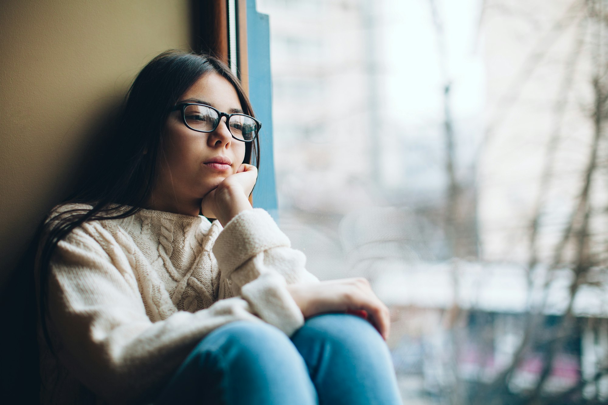 sad girl looking out the window